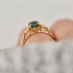 oval green teal sapphire trilogy engagement ring in yellow gold
