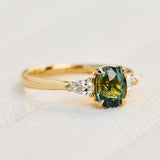 oval green teal sapphire trilogy engagement ring set in 18ct yellow gold