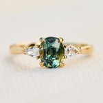 oval green teal sapphire trilogy engagement ring set in 18ct yellow gold
