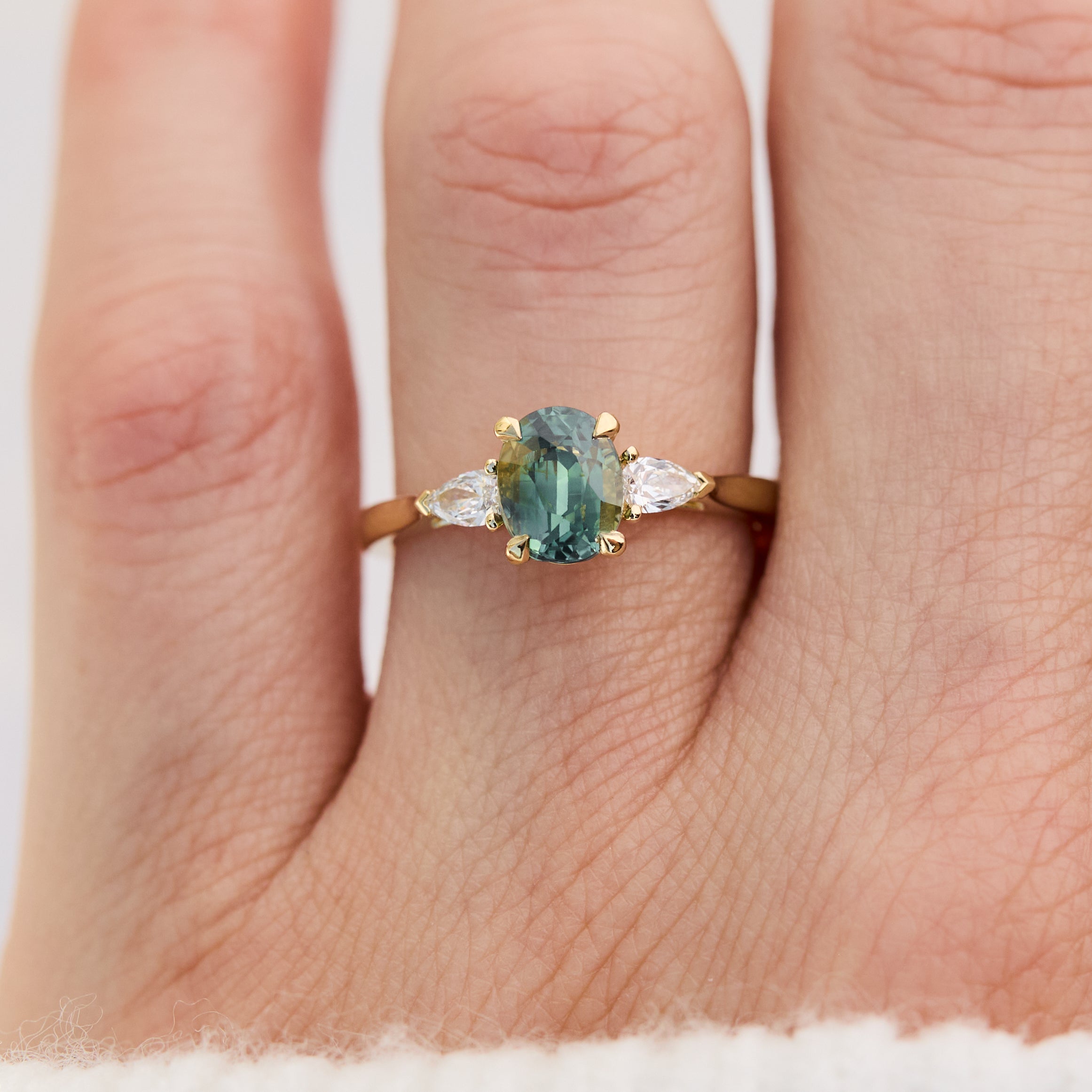 oval green teal sapphire trilogy engagement ring set in 18ct yellow gold
