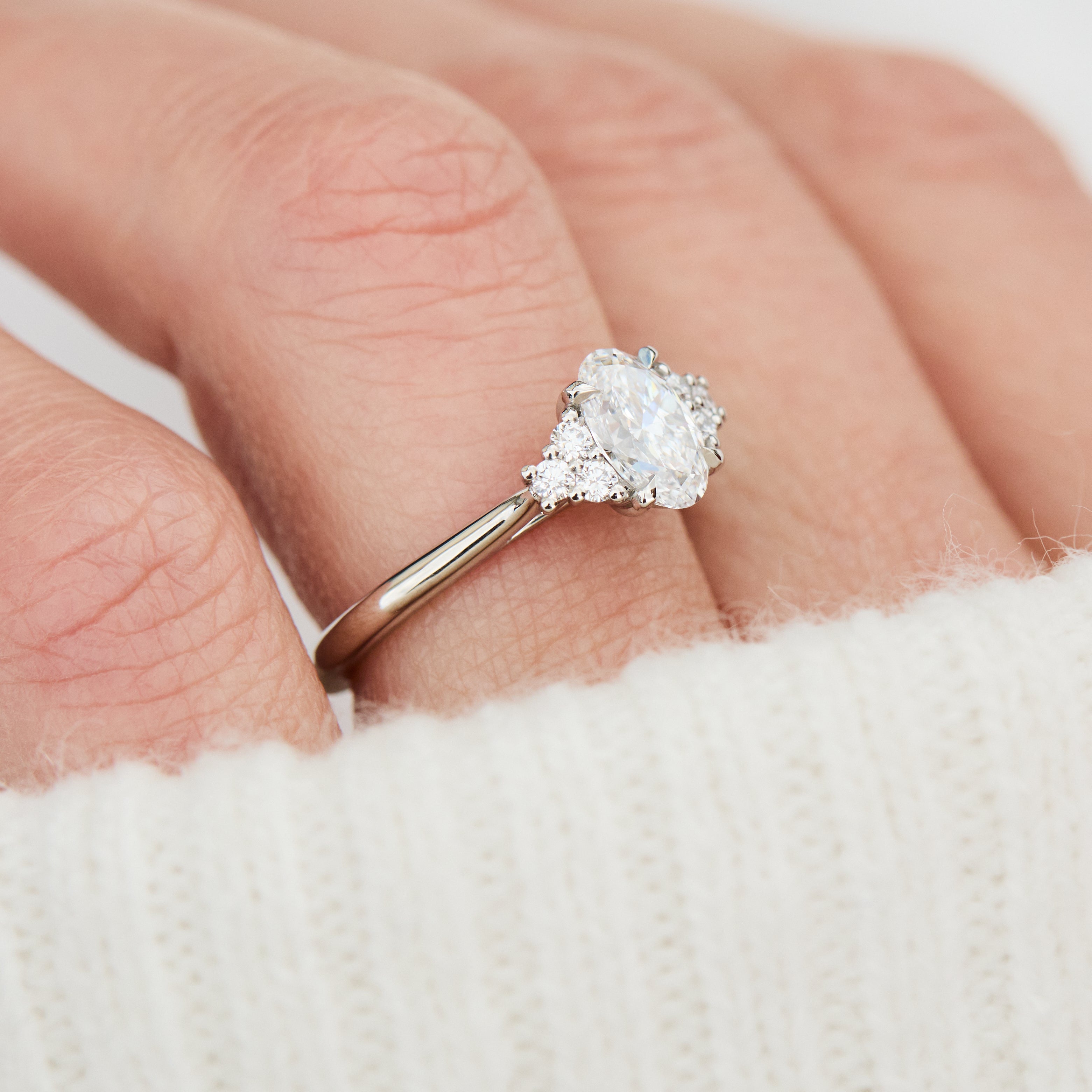 oval lab grown diamond ring in platinum paired with six round brilliant side diamonds