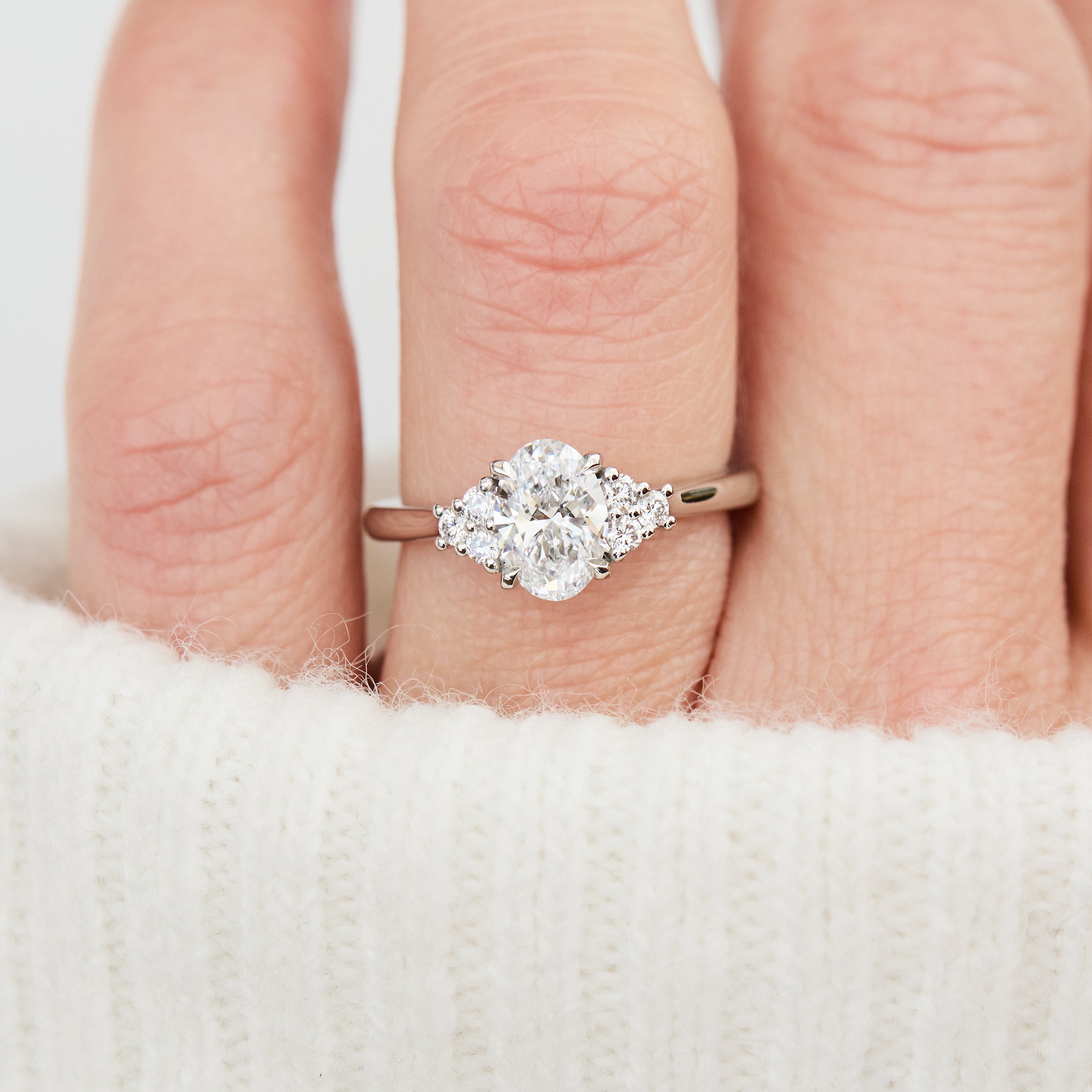 oval lab grown diamond ring in platinum paired with six round brilliant side diamonds