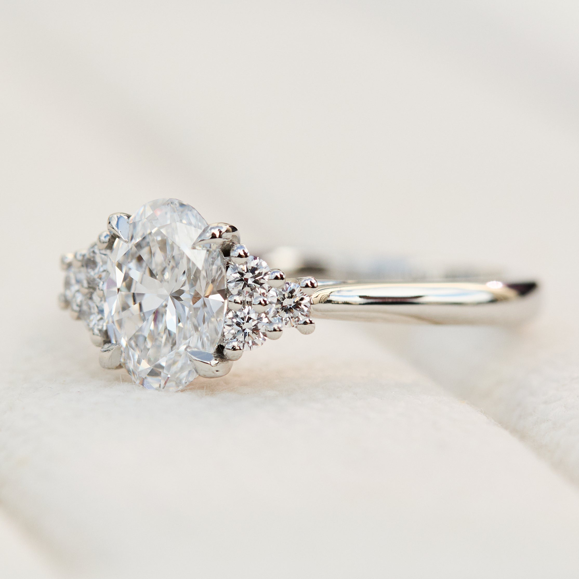 oval lab grown diamond ring in platinum paired with six round brilliant side diamonds