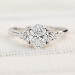 oval lab grown diamond ring in platinum paired with six round brilliant side diamonds