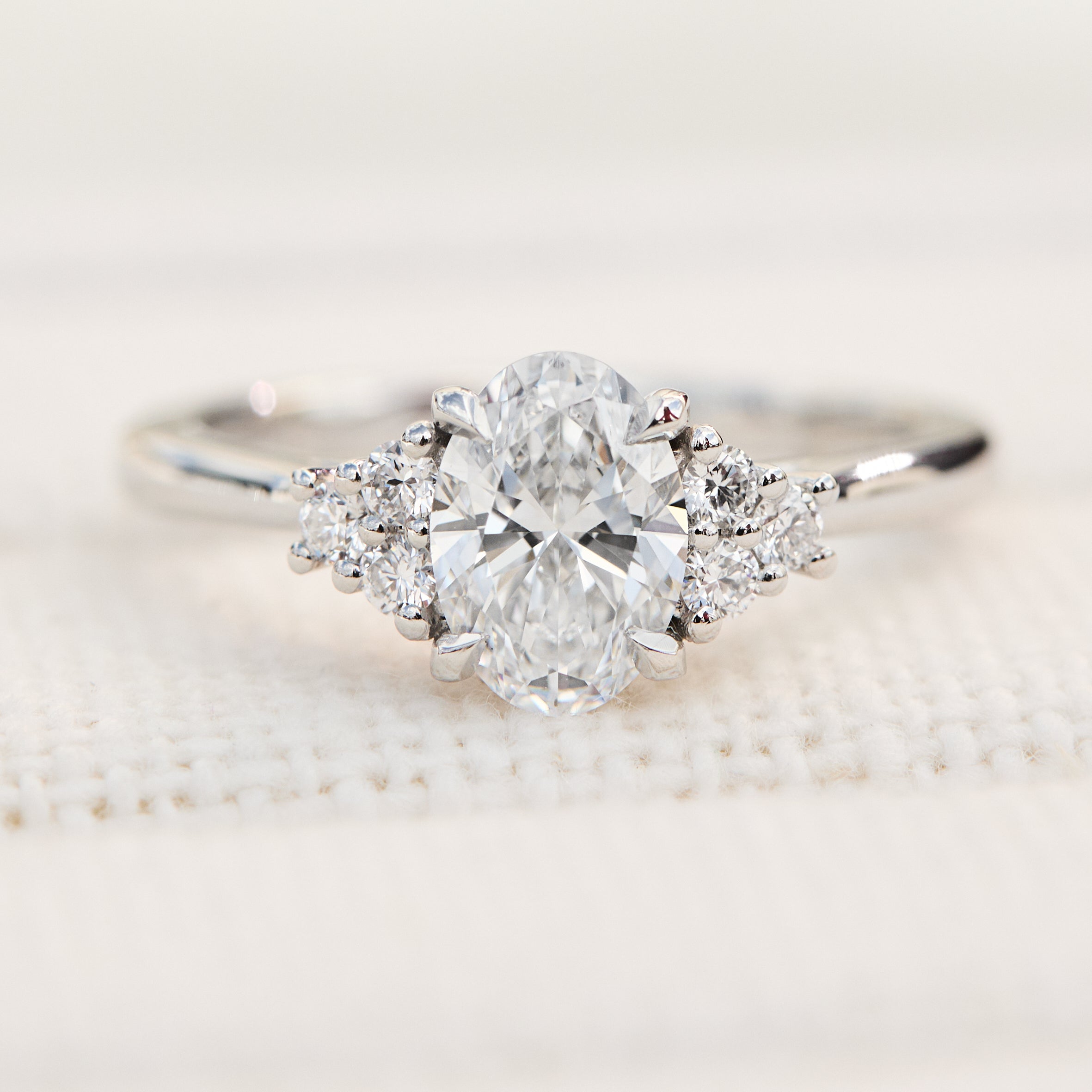 oval lab grown diamond ring in platinum paired with six round brilliant side diamonds