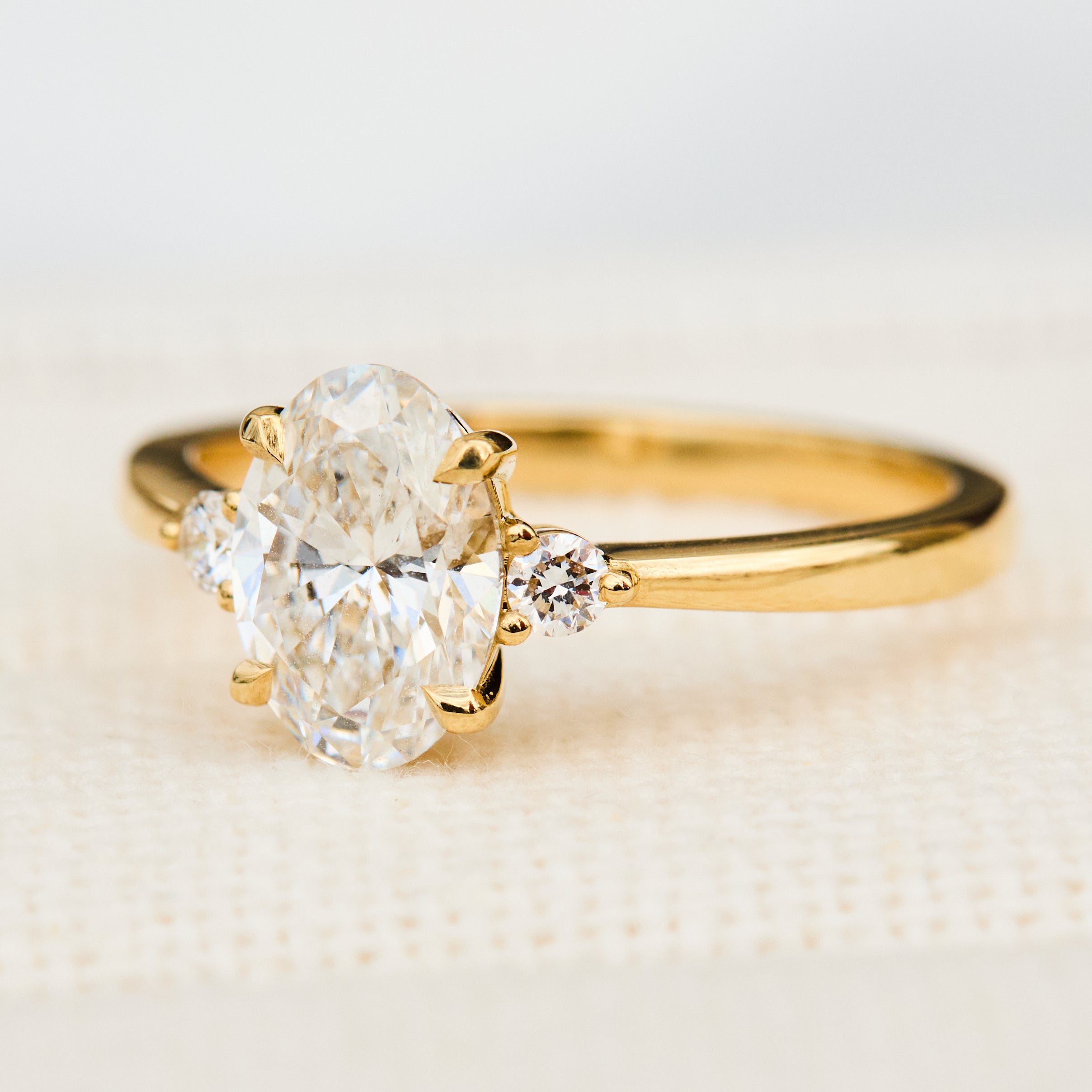 oval lab grown diamond yellow gold trilogy engagement ring