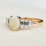 oval opal and diamond engagement ring set in yellow gold and platinum
