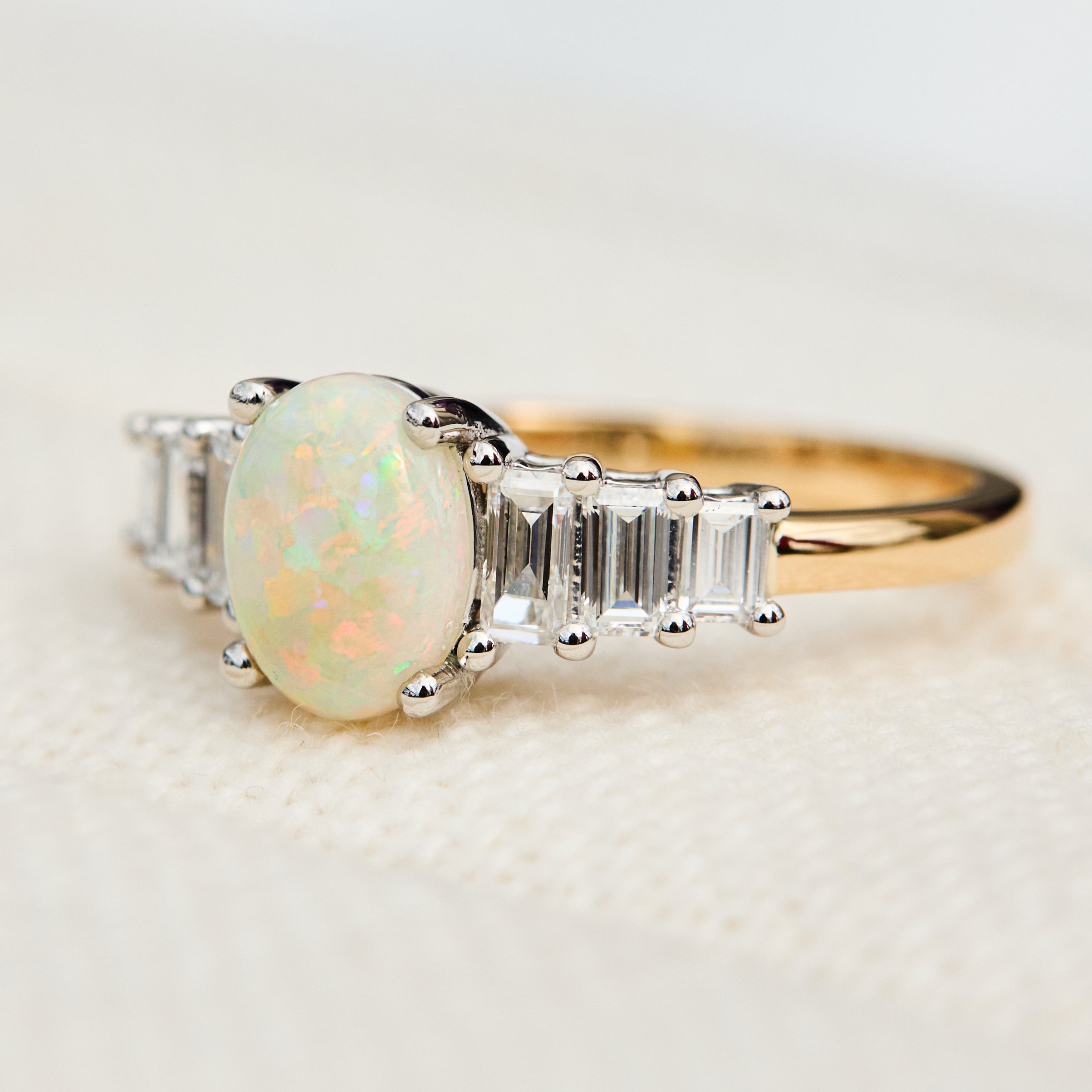 oval opal and diamond engagement ring set in yellow gold and platinum