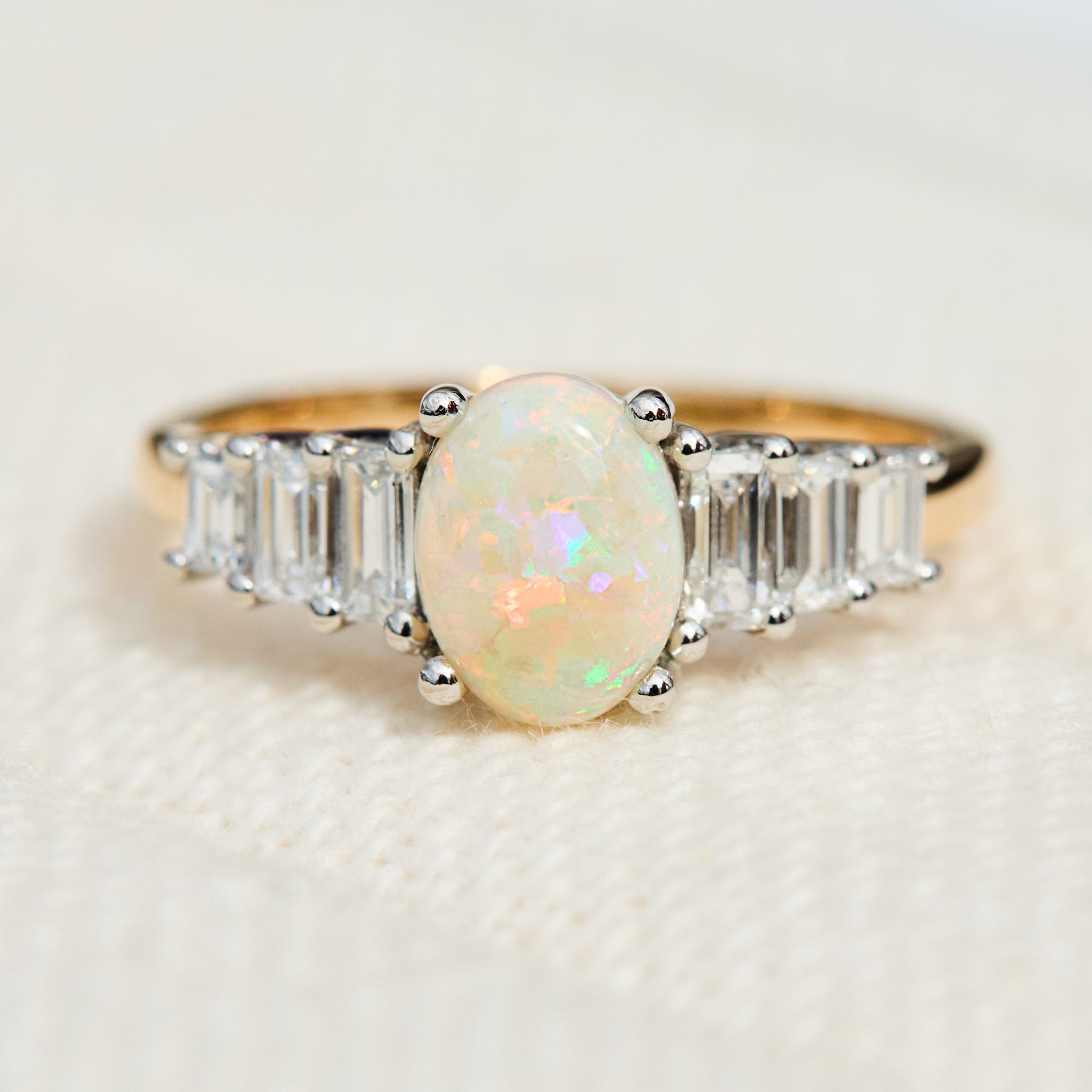 oval opal and diamond engagement ring set in yellow gold and platinum