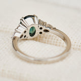 oval teal sapphire engagement ring set in platinum accented by six side diamonds
