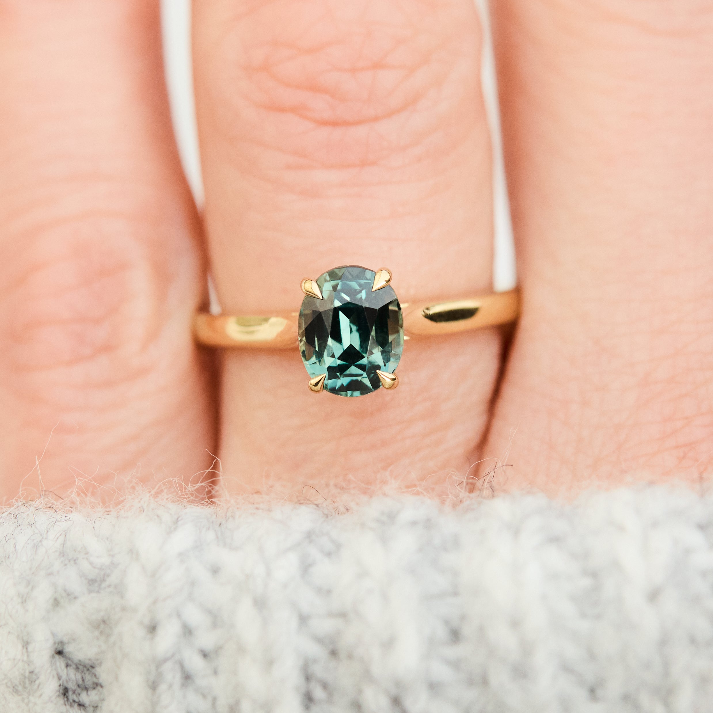 oval teal sapphire solitaire engagement ring in yellow gold