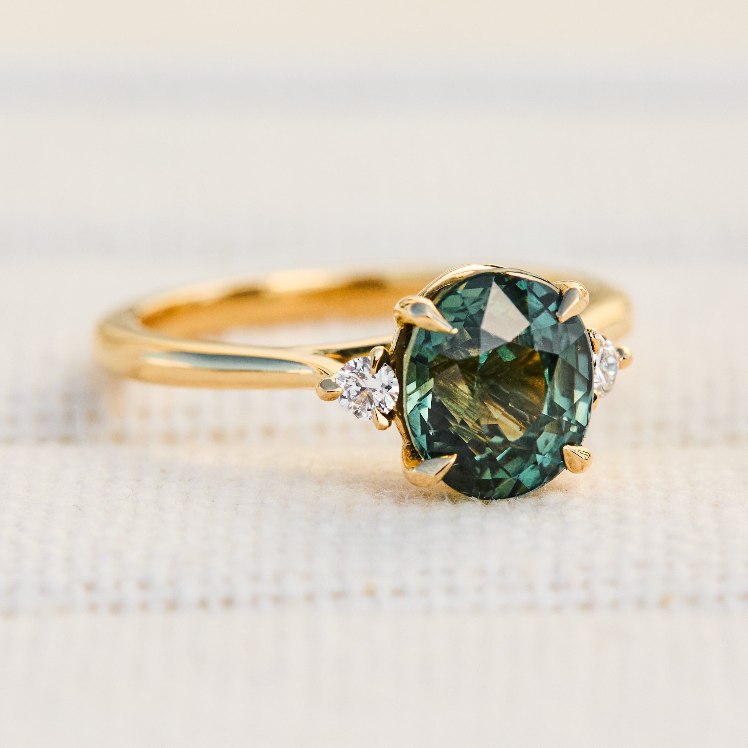 oval sapphire trilogy engagement ring in yellow gold