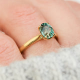 oval teal sapphire solitaire engagement ring in yellow gold
