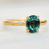 oval teal sapphire solitaire engagement ring in yellow gold