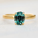 oval teal sapphire solitaire engagement ring in yellow gold