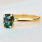 oval teal sapphire solitaire engagement ring in yellow gold
