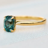 oval teal sapphire solitaire engagement ring in yellow gold