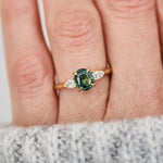 oval green teal sapphire trilogy engagement ring in yellow gold