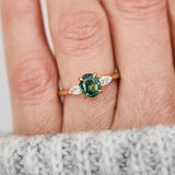 oval green teal sapphire trilogy engagement ring in yellow gold