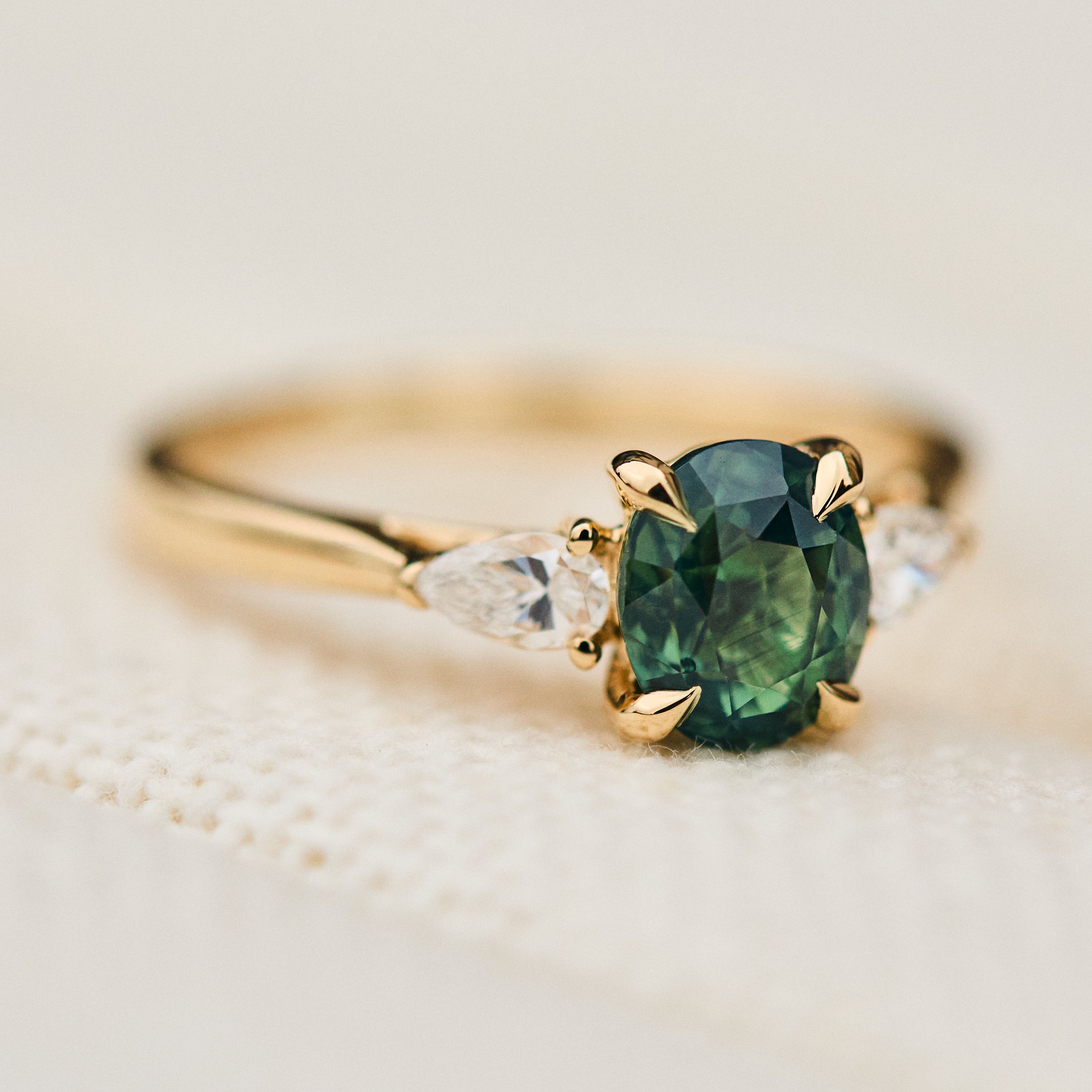 oval green teal sapphire trilogy ring in gold