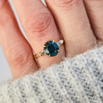 oval blue teal sapphire yellow gold engagement ring with four side stones
