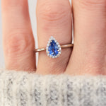 pear shape blue sapphire engagement ring with a pave halo of diamonds set in platinum