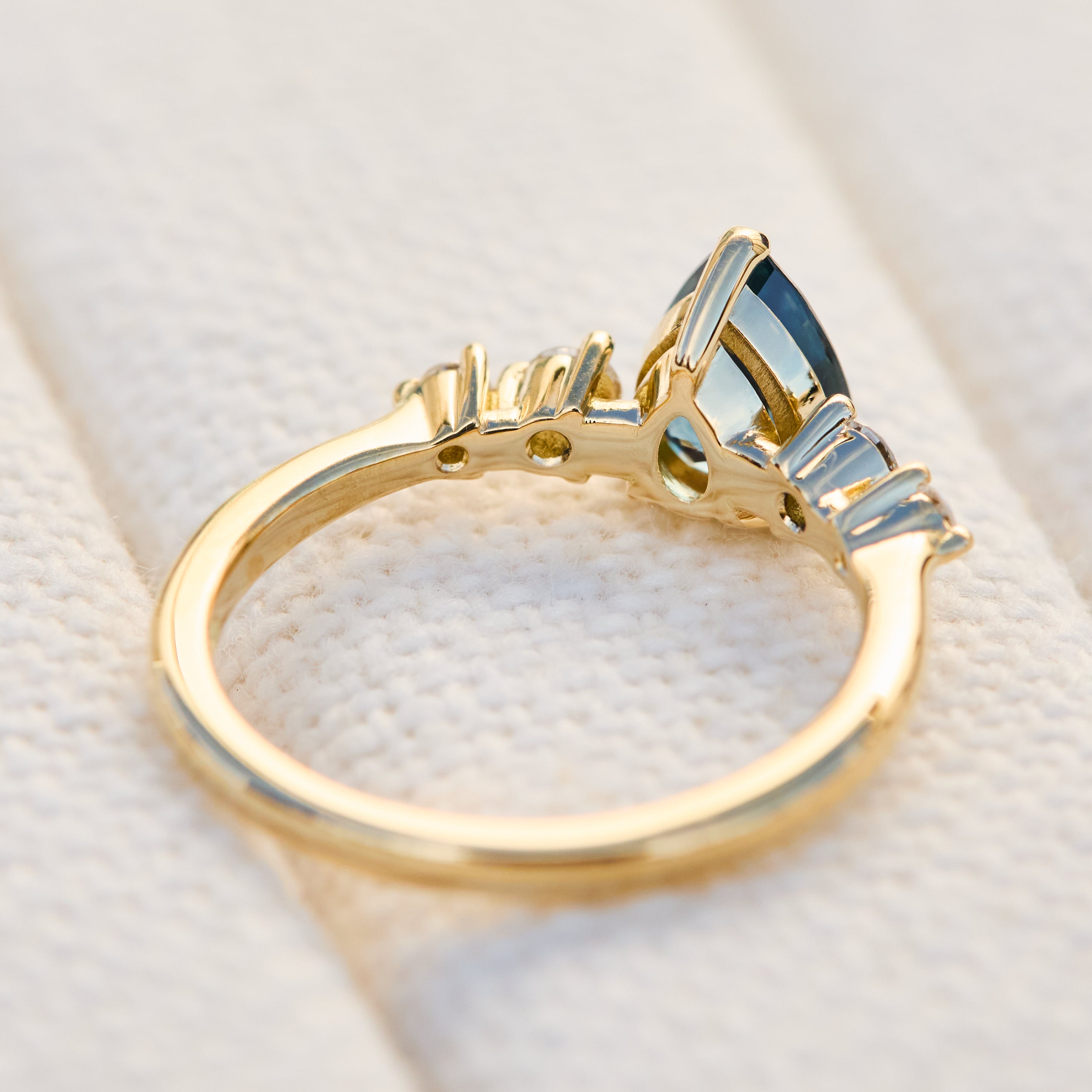 pear shape blue teal sapphire engagement ring set in yellow gold