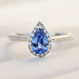 pear shape blue sapphire engagement ring with a pave diamond halo set in platinum