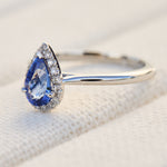 pear shape blue sapphire engagement ring with a pave diamond halo set in platinum