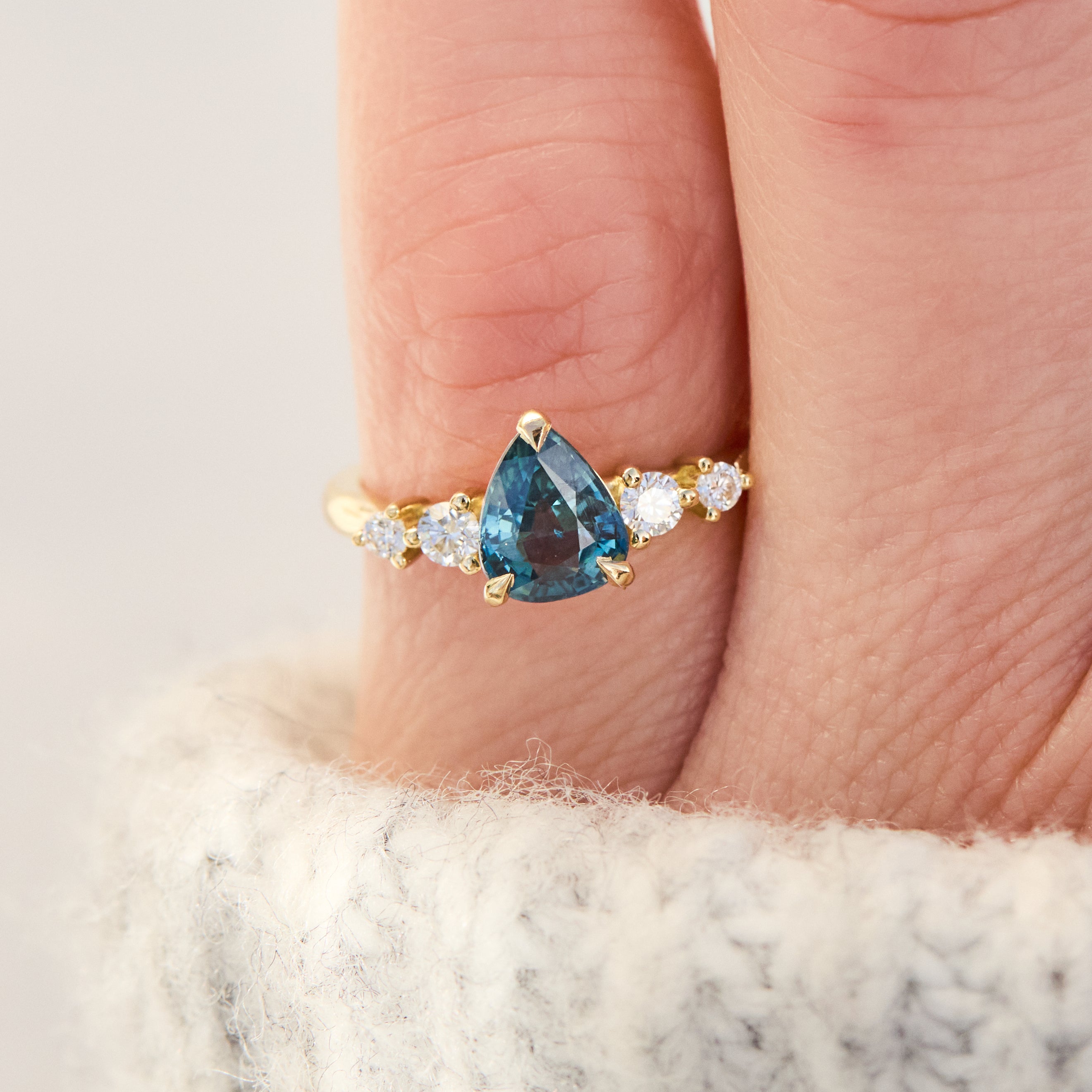 pear shape blue teal sapphire engagement ring set in yellow gold