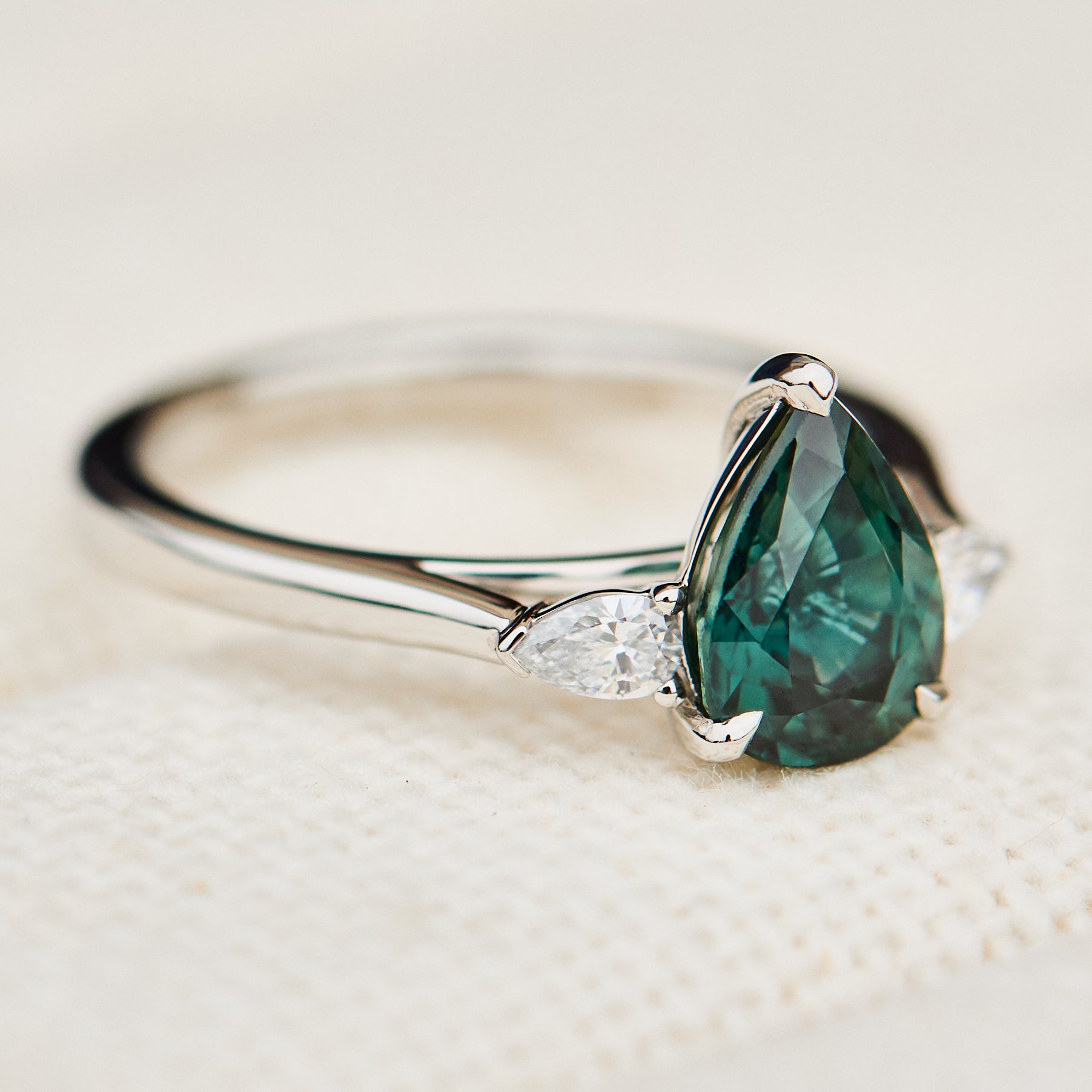pear shape green teal sapphire trilogy engagement ring in platinum