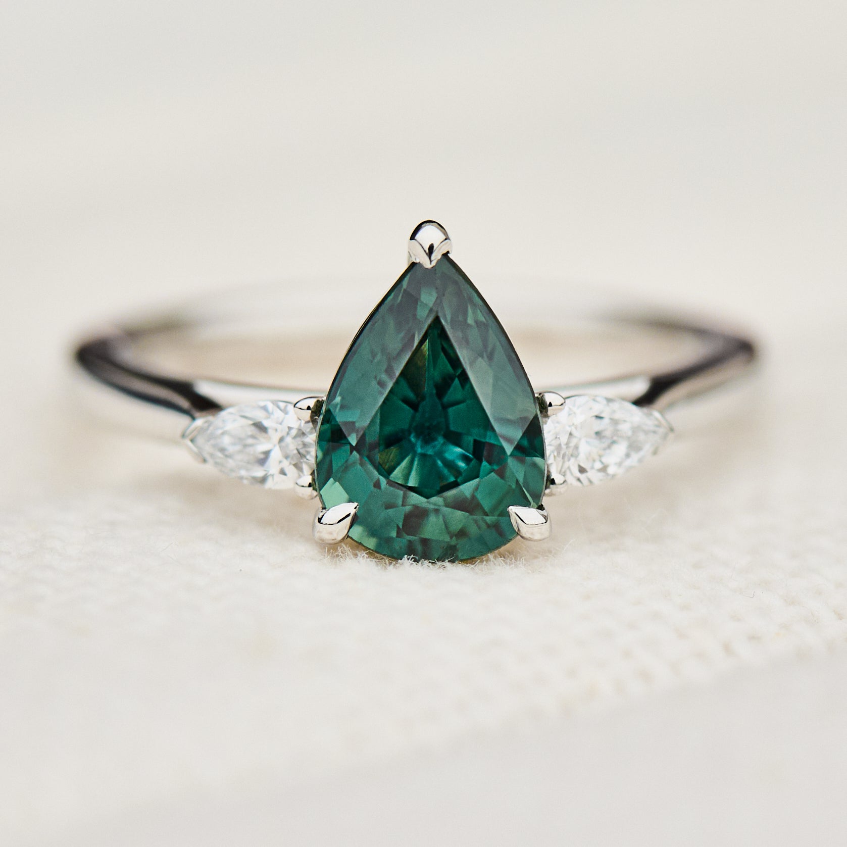 pear shape green teal sapphire trilogy engagement ring in platinum