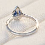pear shape blue sapphire engagement ring with a pave diamond halo set in platinum