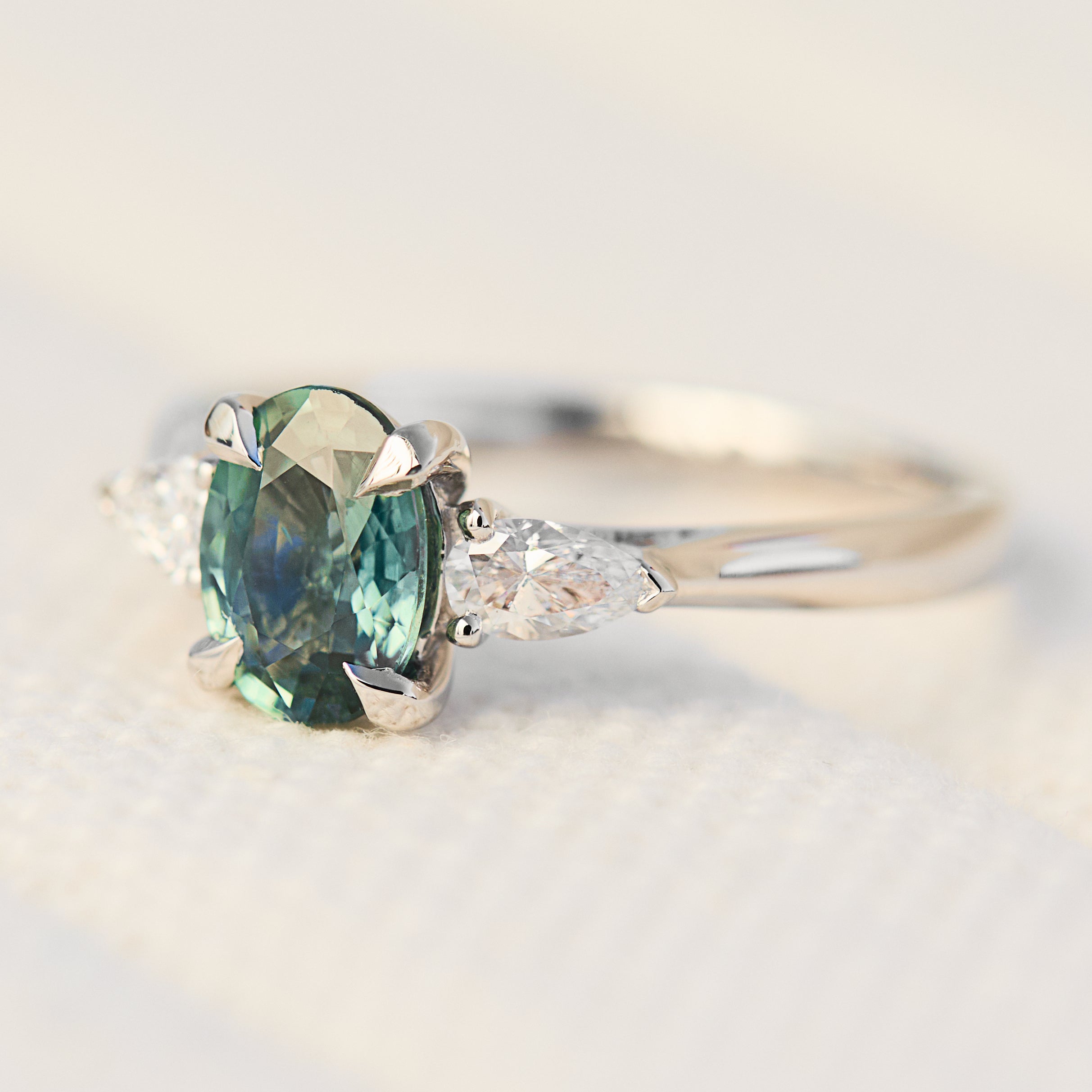 platinum oval teal sapphire engagement trilogy ring