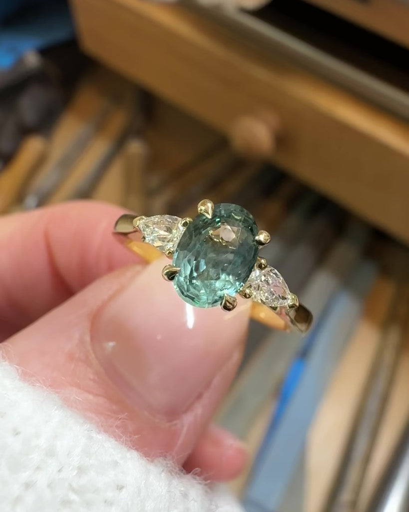 oval blue teal montana sapphire engagement ring in yellow gold