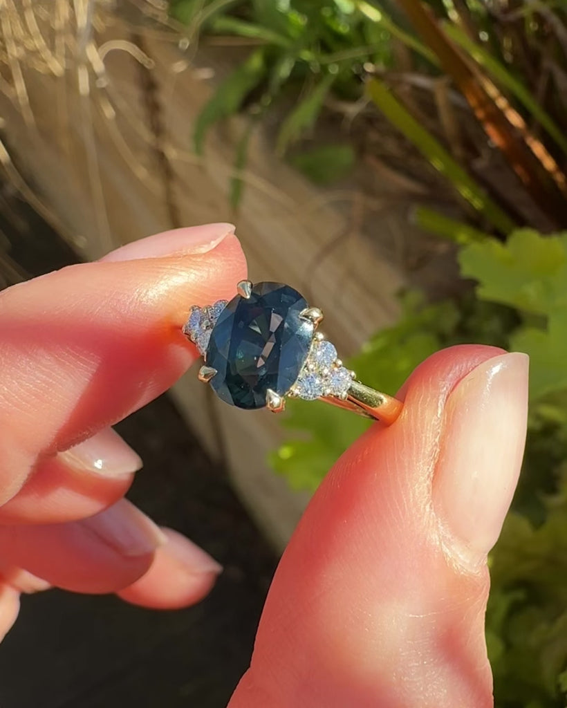 australian oval teal sapphire engagement ring with round diamond side stones