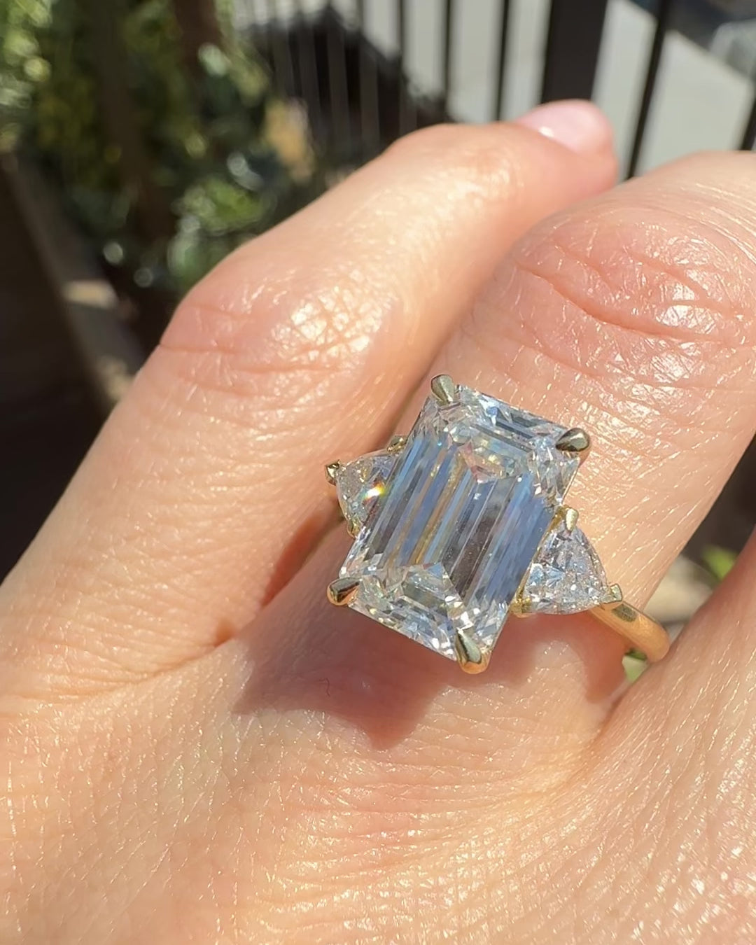 emerald cut lab grown diamond trilogy engagement ring set in yellow gold