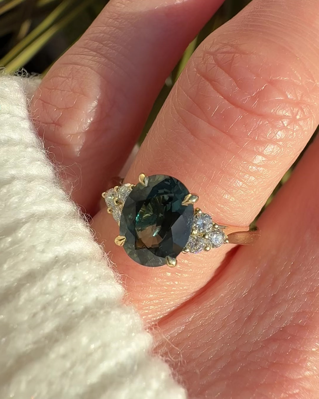 oval green teal sapphire engagement ring paired with diamonds