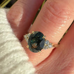 oval green teal sapphire engagement ring paired with diamonds