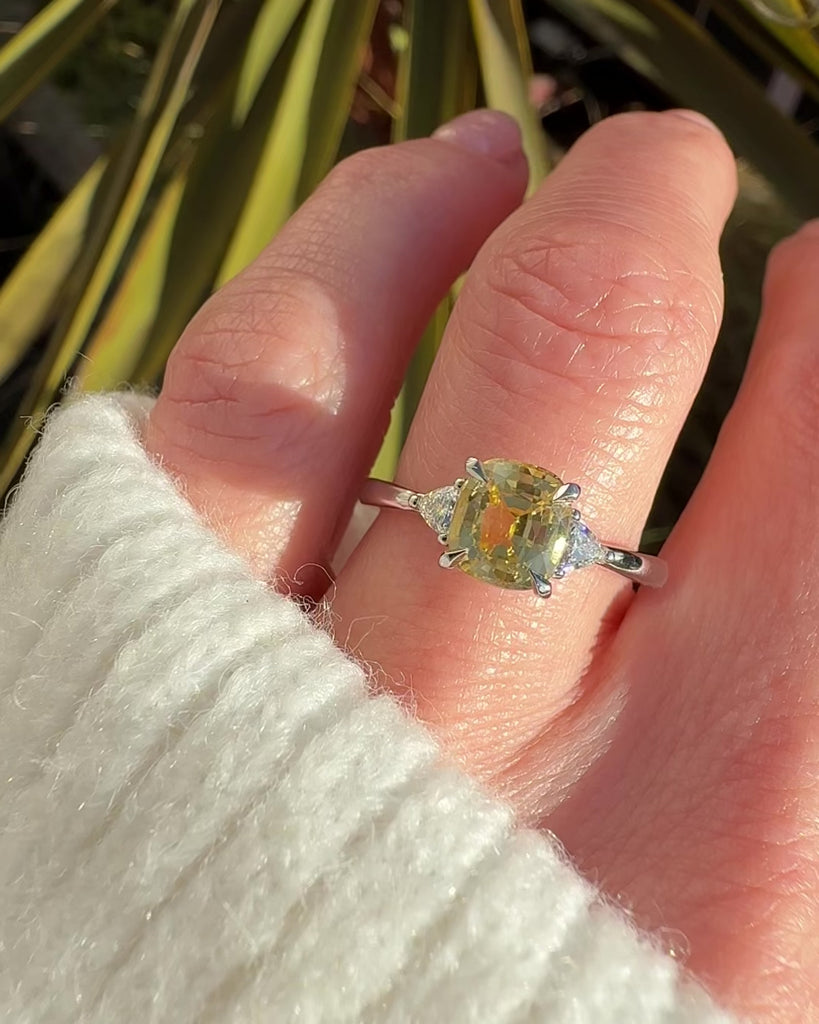 cushion cut yellow sapphire trilogy engagement ring in platinum