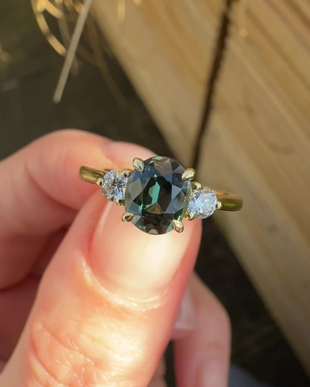 tanzanian oval teal sapphire trilogy engagement ring in yellow gold