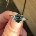 tanzanian oval teal sapphire trilogy engagement ring in yellow gold