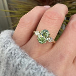 oval green lab grown diamond trilogy engagement ring in yellow gold