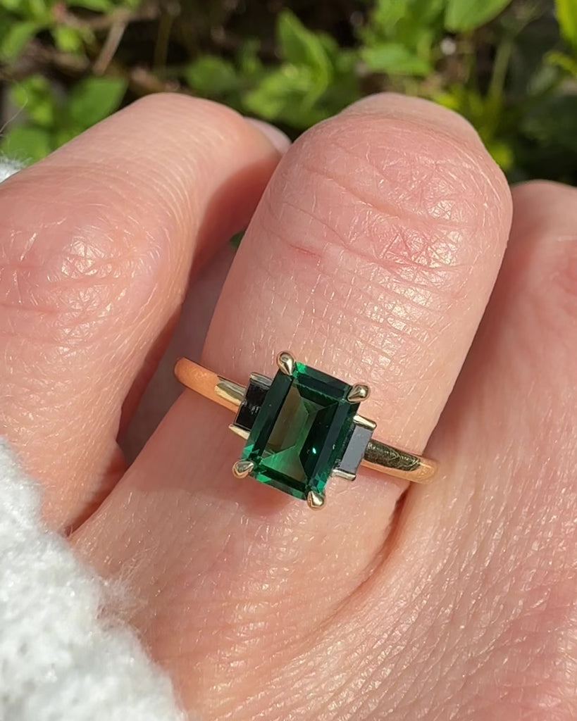 emerald cut emerald trilogy engagement ring set in yellow gold