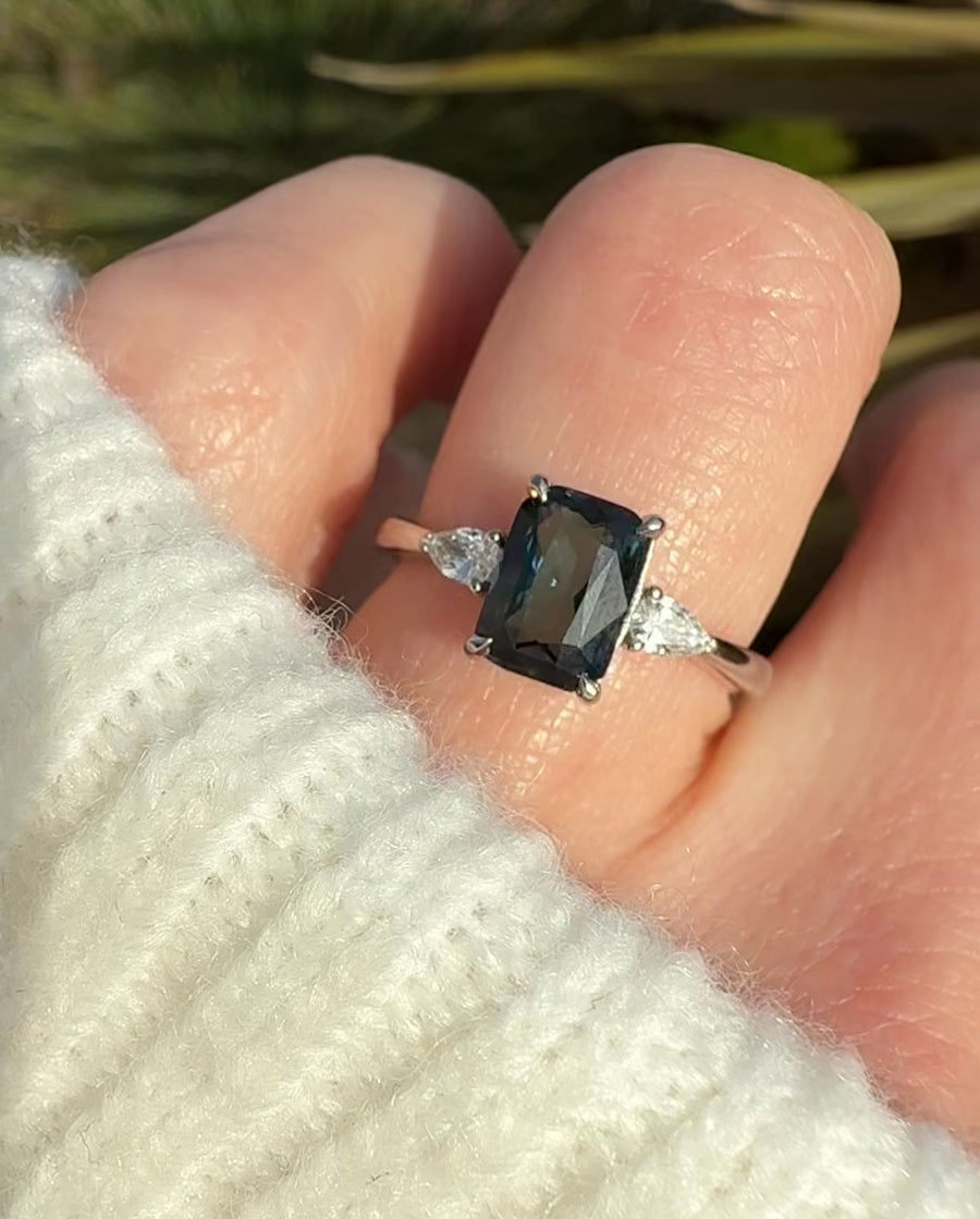 emerald cut blue teal sapphire trilogy engagement ring in platinum