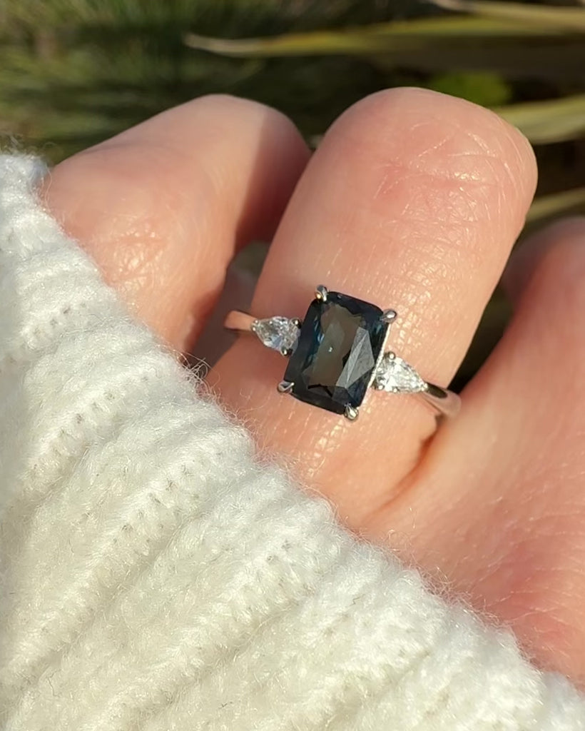 emerald cut blue teal sapphire trilogy engagement ring in platinum