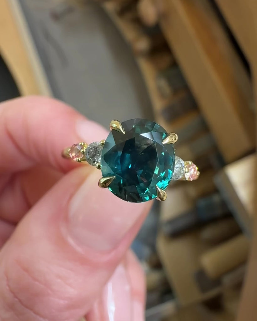 oval blue teal sapphire yellow gold engagement ring with four side stones