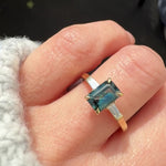 emerald cut teal sapphire trilogy engagement ring in yellow gold