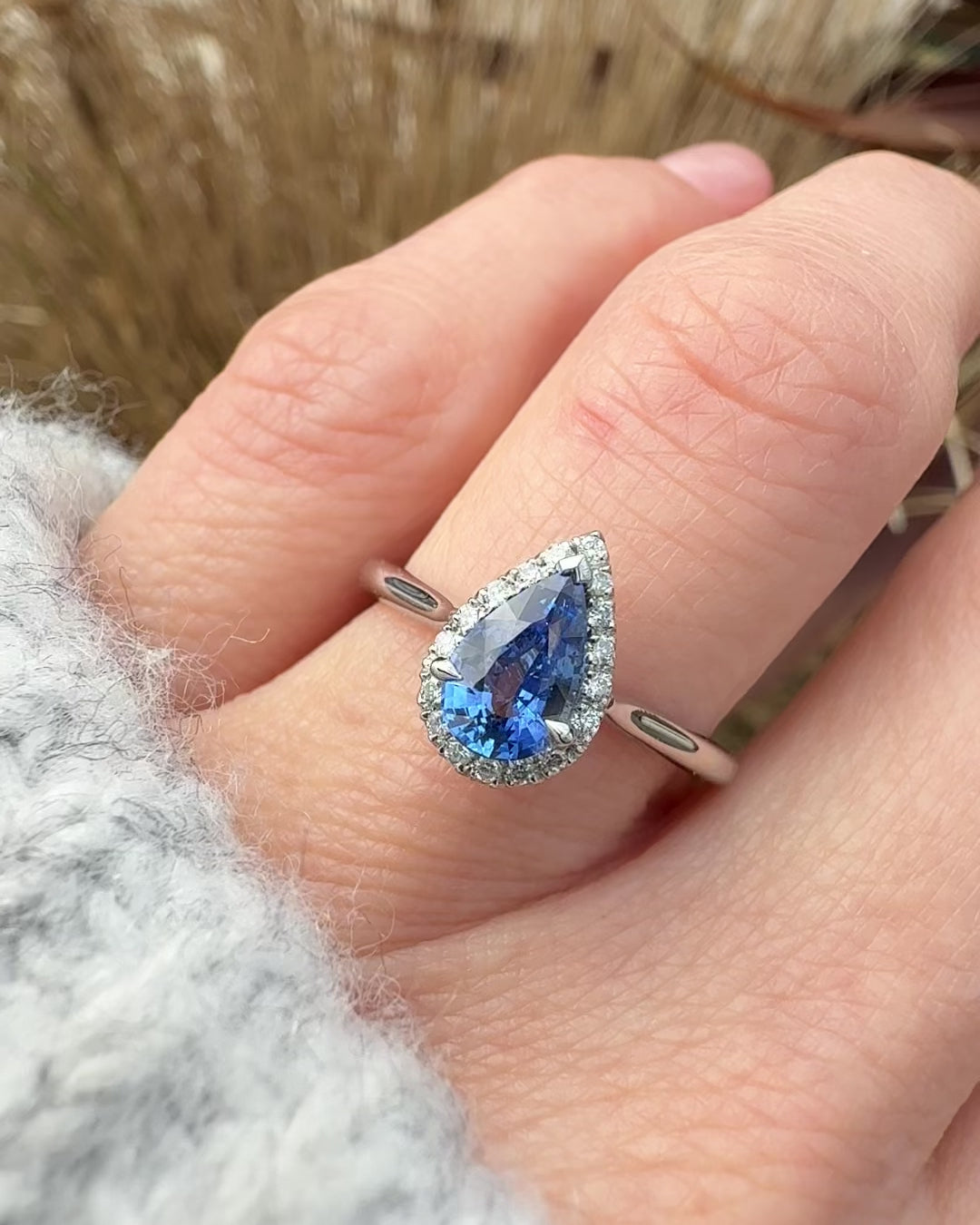 pear shape blue sapphire engagement ring with a pave diamond halo set in platinum