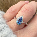 pear shape blue sapphire engagement ring with a pave diamond halo set in platinum